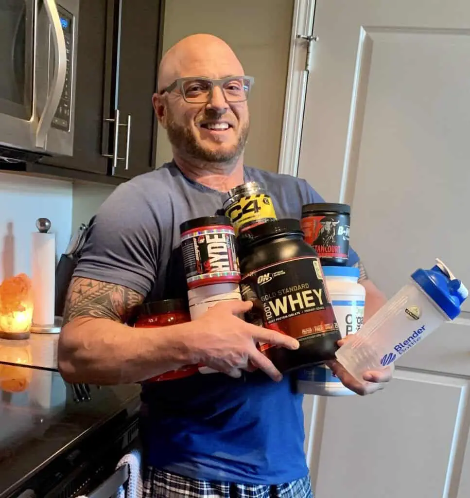 What is the Best Pre Workout Supplement - me holding supplements