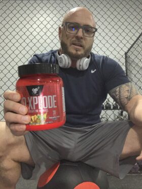 NO Xplode pre workout reviews - me holding container of pre workout