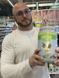 Get "Amped" Up with a Vegan Pre Workout Supplement - me holding vega one protein powder